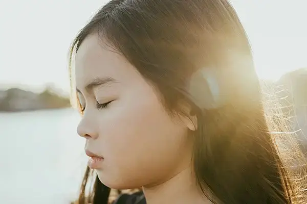 Child with eyes closed practicing a mindfulness exercise learned in therapy sessions in Agoura Hills, CA, showcasing valuable coping skills developed through child therapy