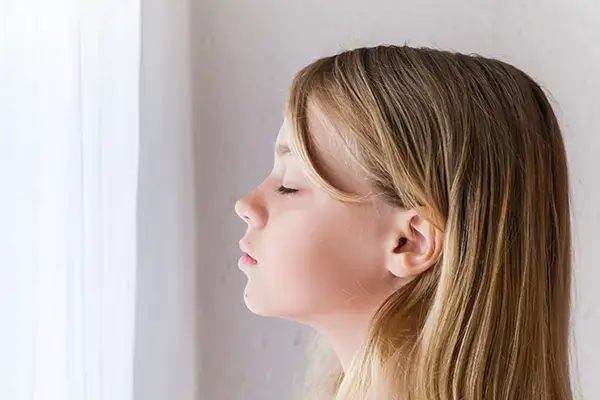 Blond tween girl with eyes closed practicing mindfulness exercises learned in child therapy sessions in Westlake Village, CA, showcasing the valuable coping skills developed through therapy