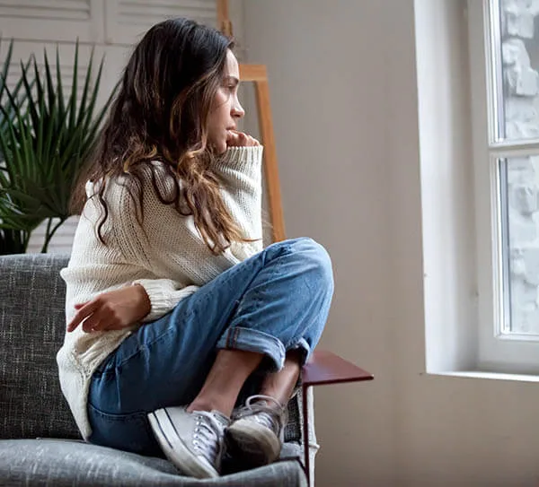 Teen girl with anxiety sitting by a window during an anxiety therapy session near Studio City